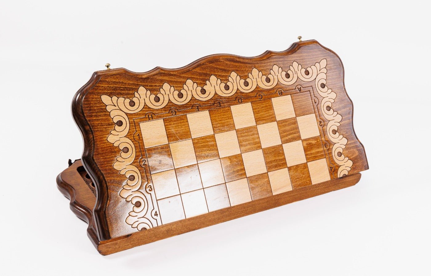 Wooden chessboard with decorative border on a white background