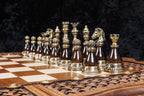 Bronze king, queen, bishop, knight and rook on dark bases on the chessboard, close-up