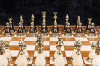 Bronze chess pieces on cream and dark bases lined up on the chessboard, close-up