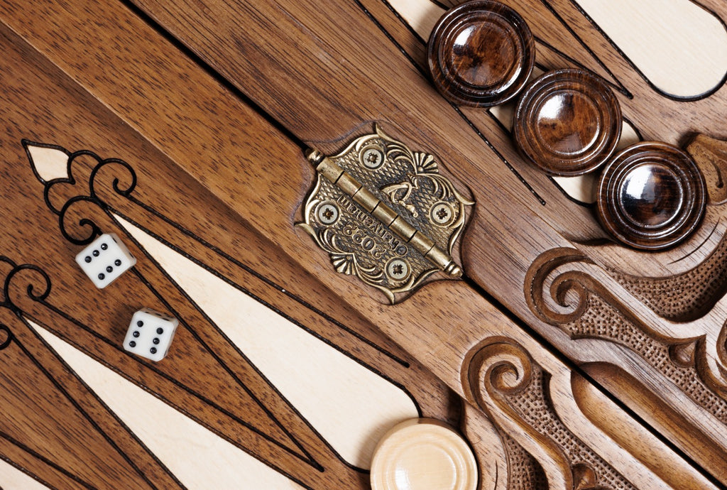 Stamped cast-bronze hinge on the bar of the open backgammon board with checkers and dice