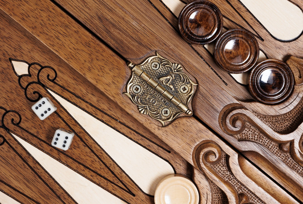 Stamped cast-bronze hinge on the bar of the open backgammon board with checkers and dice