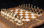 Bronze chess pieces on cream and dark bases set up on the walnut and hornbeam chessboard, angled view