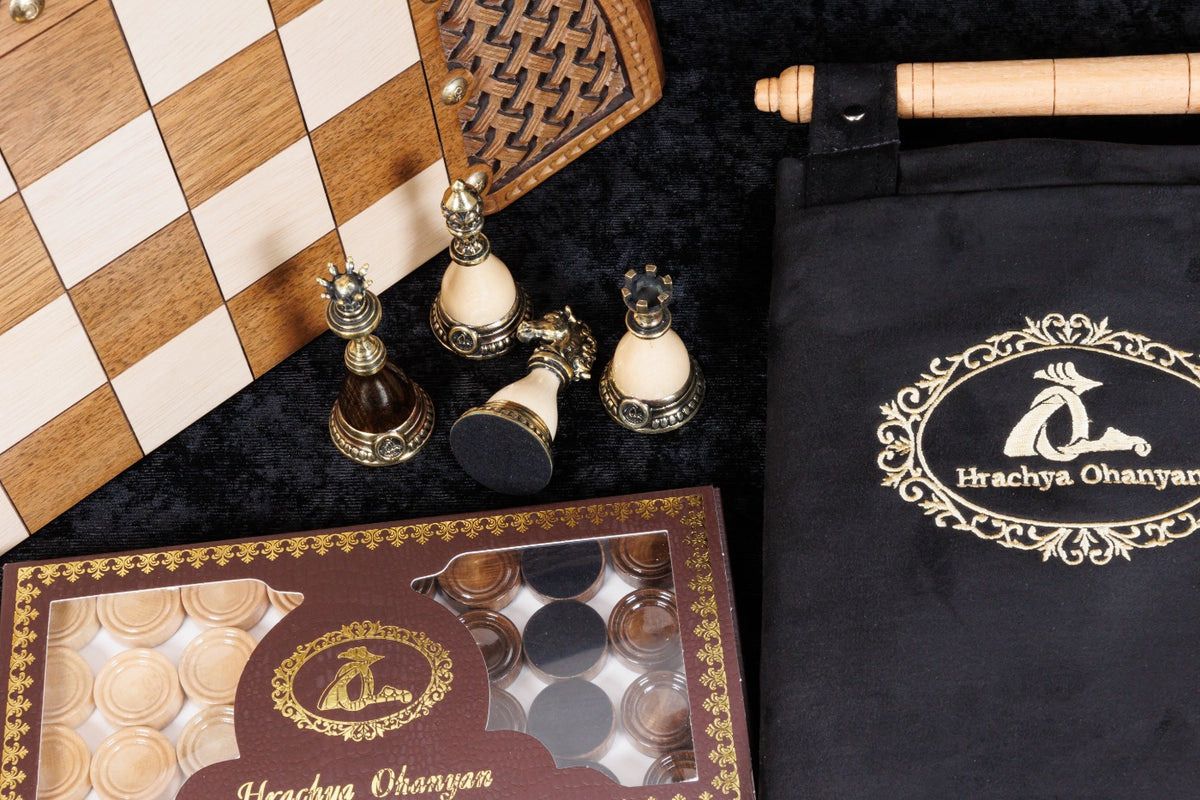 Bronze chess pieces beside the Hrachya Ohanyan checkers box and black carrying case