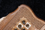 Checkers with cast emblems in the corner of the chessboard beside the braid frame