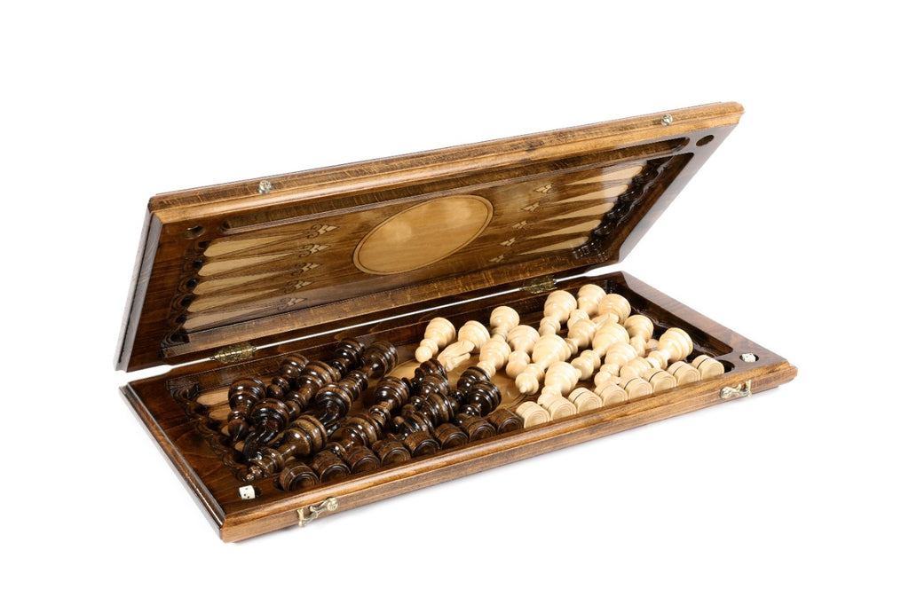 Chess backgammon set half open with the hand-carved pieces stored on the backgammon field