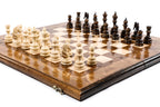 Large handmade chess board with plain wooden frame and hand-carved pieces, close angle