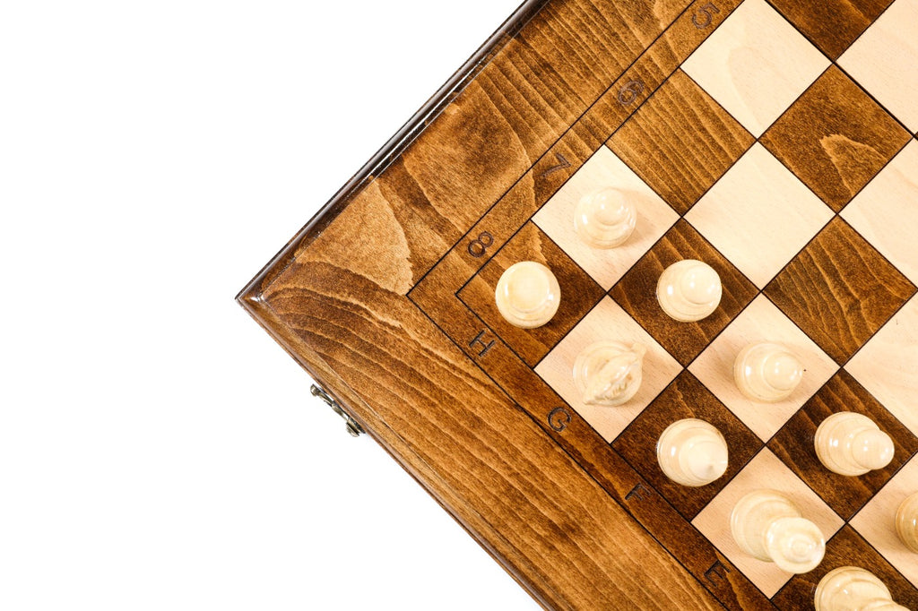 Close view of light chess pieces on the plain classic chess board