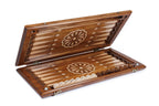 Backgammon board half open showing the dark field, pale fleur-de-lys points and wheel ornaments