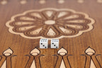 Eight-petal wheel ornament with two dice on the dark field of the open backgammon board