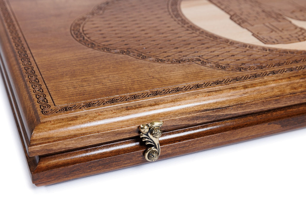Edge of the closed backgammon board with the cast-bronze clasp and layered lattice lid