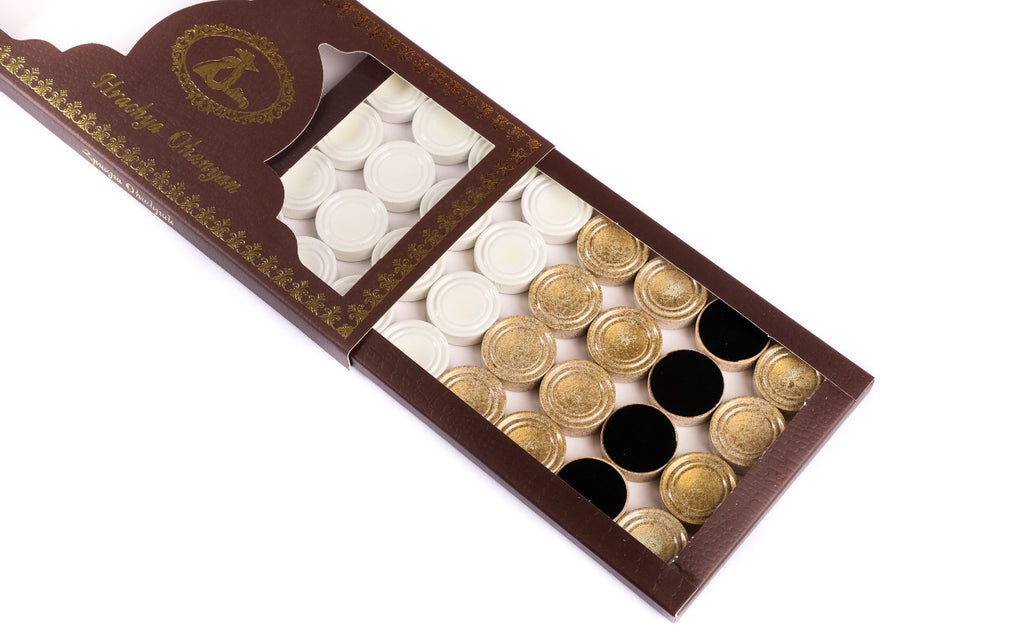 White and gold checkers of the Armenian backgammon set in the branded box