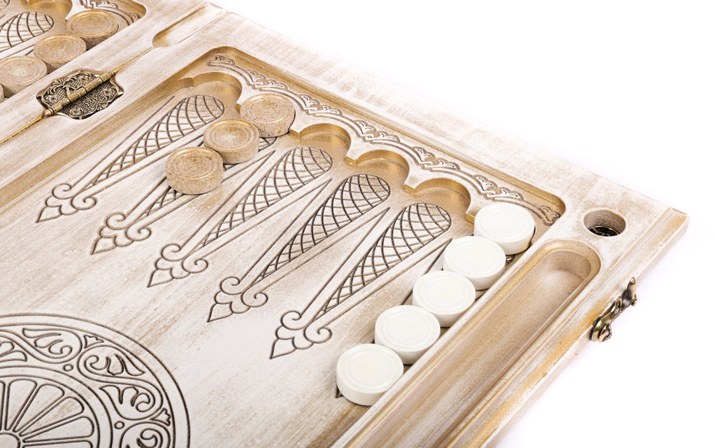 White checkers on the pale points of the open board beside the wheel ornament and the dice hollow
