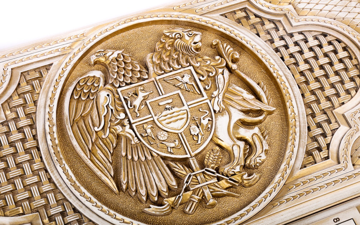 Close-up of the coat of arms: eagle and lion holding the shield with Ararat, carved in deep relief and aged with gold