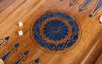 Wheel ornament in blue epoxy with two dice on the open walnut backgammon board