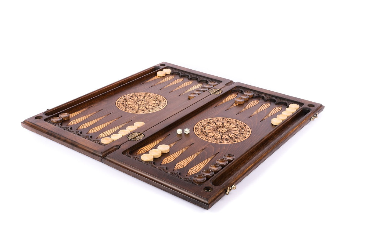 Chip-carved backgammon set open with pale and dark checkers and dice on the 60 cm board, angled view