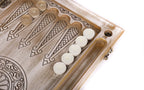 Points drawn in line with fleur-de-lys tips and white checkers on the open backgammon board