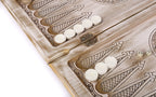 Two dice and white checkers on the open white and gold backgammon board, hinge on the bar