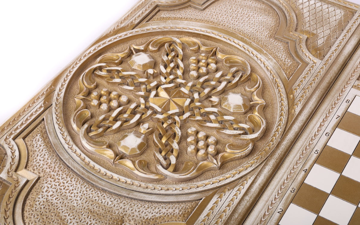 Close-up of the pomegranates and grapes carved in deep relief, gold in the hollows of the fruit