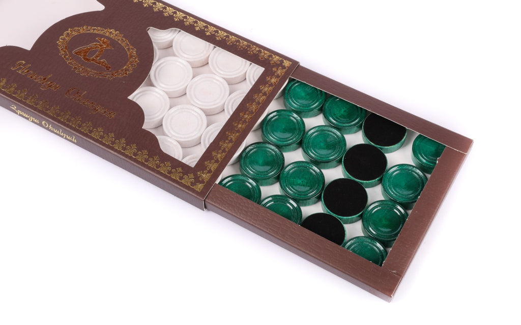 White and green checkers of the backgammon set in the branded box