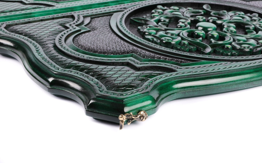 Close-up of the carved scroll ornament and lattice on the green contour lid, cast-bronze clasp at the edge