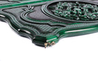 Close-up of the carved scroll ornament and lattice on the green contour lid, cast-bronze clasp at the edge