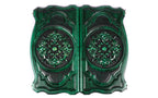 Both covers of the green backgammon set with the same scroll ornament in high relief, seen from above