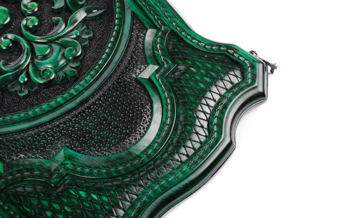 Corner of the green lid: lattice cartouche, rope border and scalloped contour edge, close-up