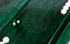 Wheel ornament and two dice on the open green backgammon board