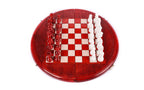 Top-down view of the round red and white chess set with pieces lined up beside the field
