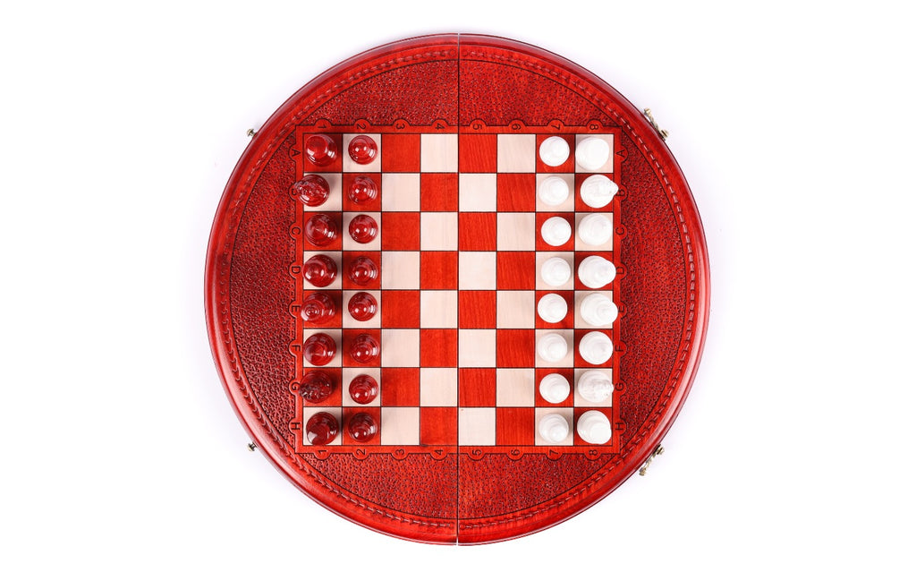 Top-down view of the round chess set with all 32 red and white pieces in starting position