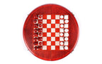 Top-down view of the round chess set with all 32 red and white pieces in starting position