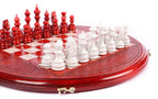White painted chess pieces close up on the round wooden chess board