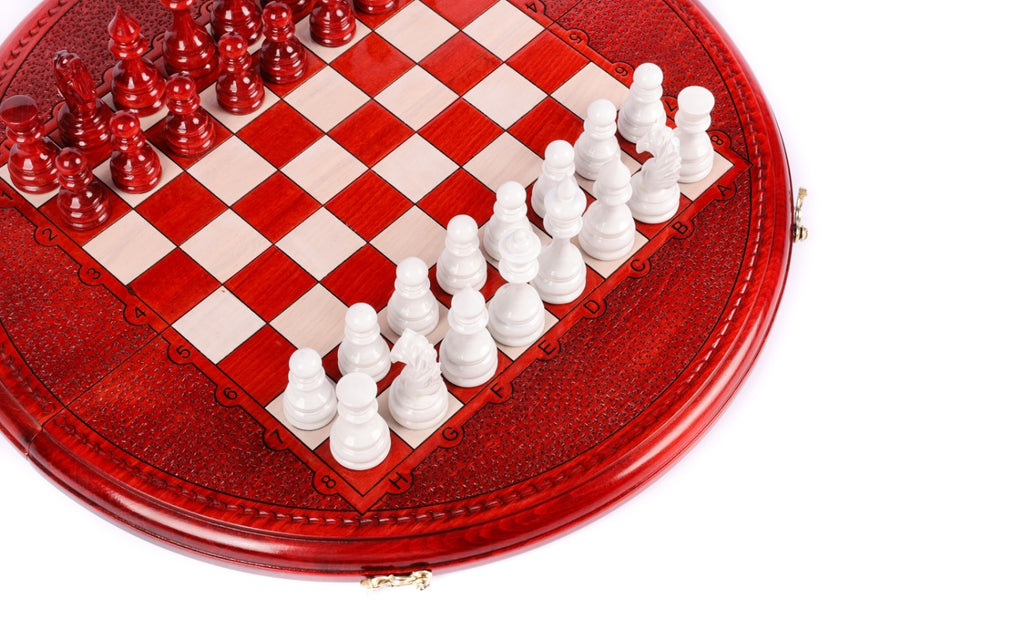Angled view of the round red chess set with white pieces and carved coordinates