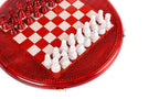 Angled view of the round red chess set with white pieces and carved coordinates