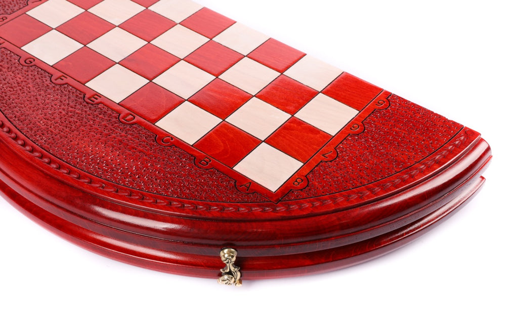 Close view of the red and cream checkered field and carved rim of the round board