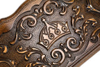 Close-up of the carved crown with its arches and pearls among the rococo scrolls