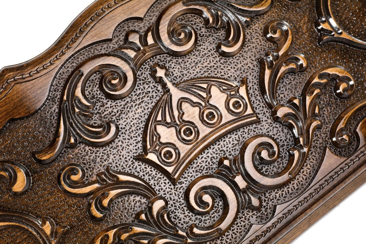 Close-up of the carved crown with its arches and pearls among the rococo scrolls