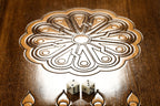 Wheel ornament with two dice on the open backgammon board, fleur-de-lys points below