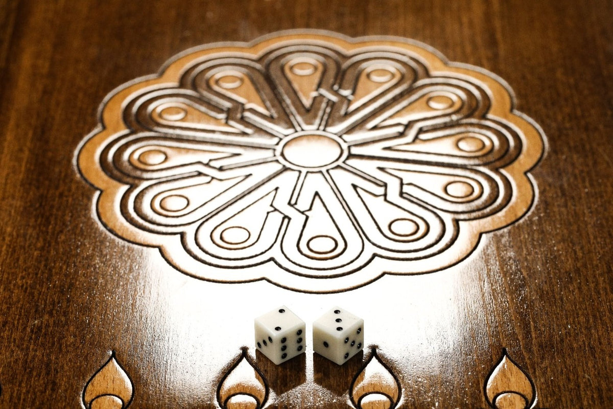 Wheel ornament with two dice on the open backgammon board, fleur-de-lys points below