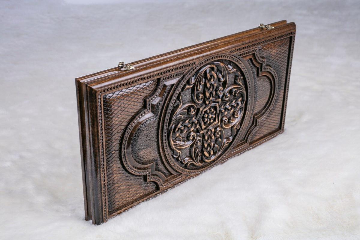 Closed backgammon board standing on edge, braided cross in an oval medallion with rope border