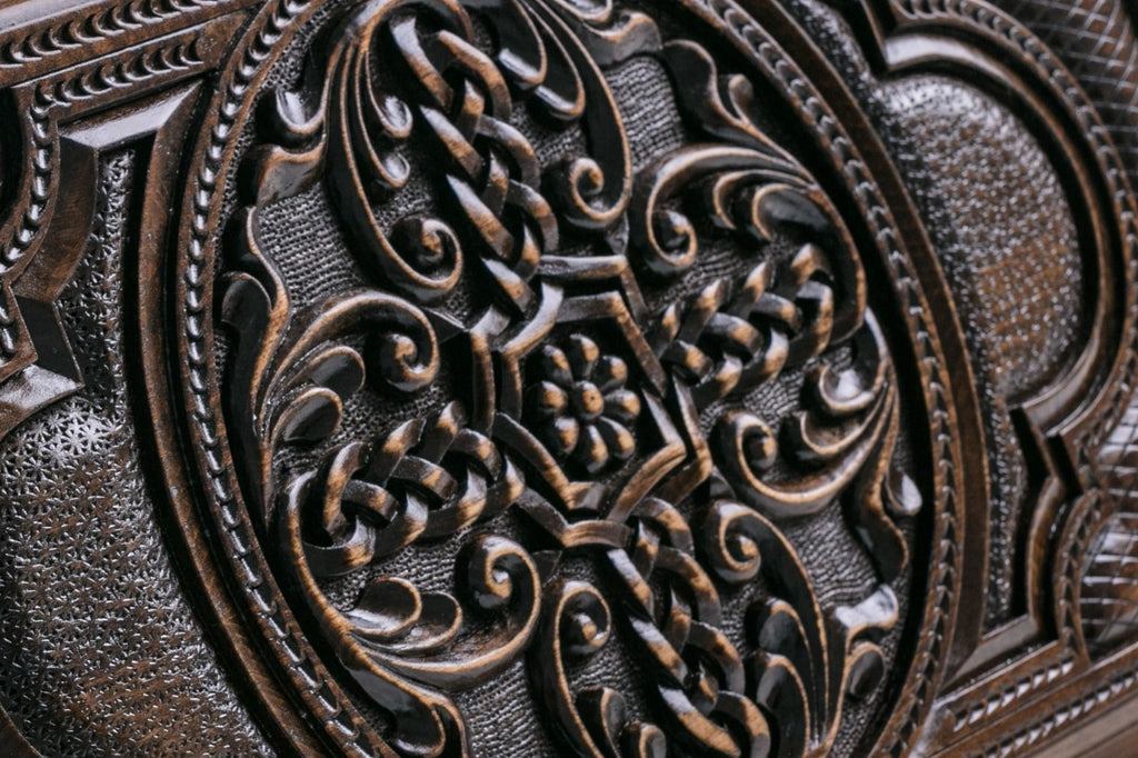 Close-up of the braided cross carved in high relief with a flower at its centre