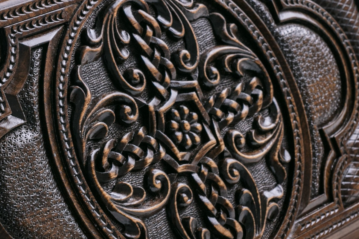 Close-up of the braided cross carved in high relief with a flower at its centre