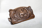Closed backgammon board on edge, a stag with raised antlers and a doe resting in the grass