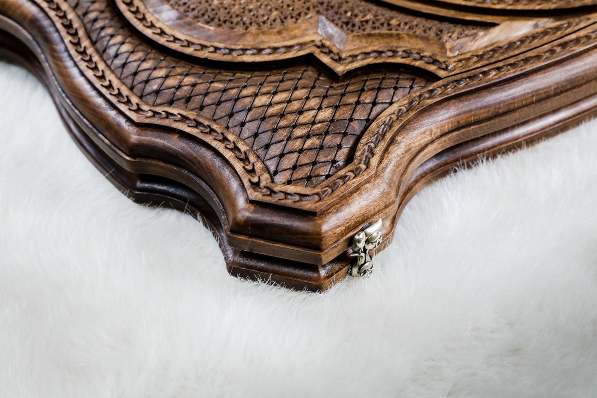 Close-up of the scale lattice, rope border and shaped contour edge beside a clasp