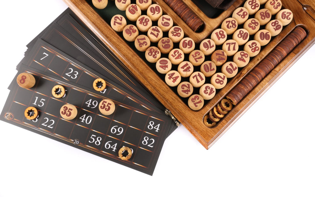 Lotto cards with wooden markers beside rows of numbered barrels
