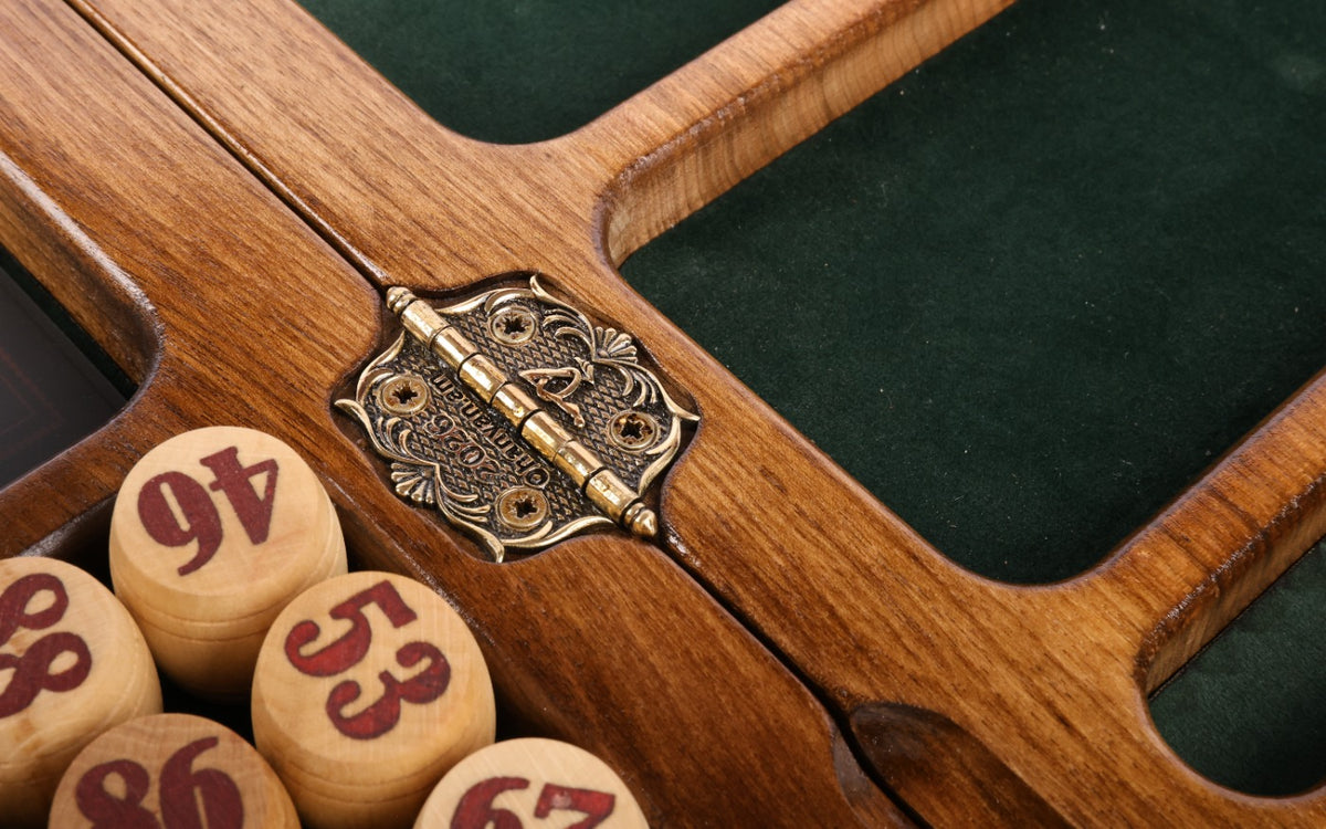 Brass hinge of the walnut lotto box next to numbered barrels