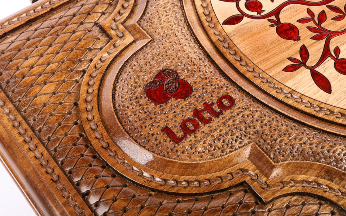 Close-up of the carved Lotto lettering and pomegranate on the lid
